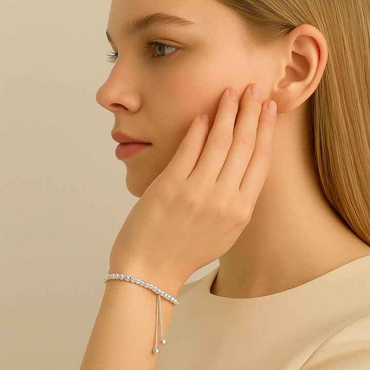  Bracelet ajustable Mila en argent 925, perles polies brillantes sur poignet féminin dans un décor lumineux