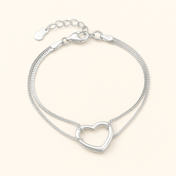 Bracelet en Argent 925 sterling avec pendentif cœur et double chaîne à maillons fins, posé à plat sur fond beige doux – Histoire d’Argent
