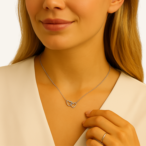 Photo mode d’un collier Histoire d’Argent porté à Paris, deux cœurs entrelacés en argent brillant, ambiance chic et romantique.