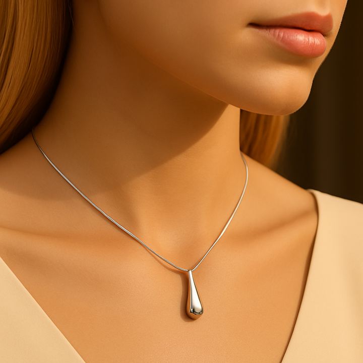 Collier en argent 925 porté par une mannequin, pendentif goutte élégante, style moderne et raffiné.

