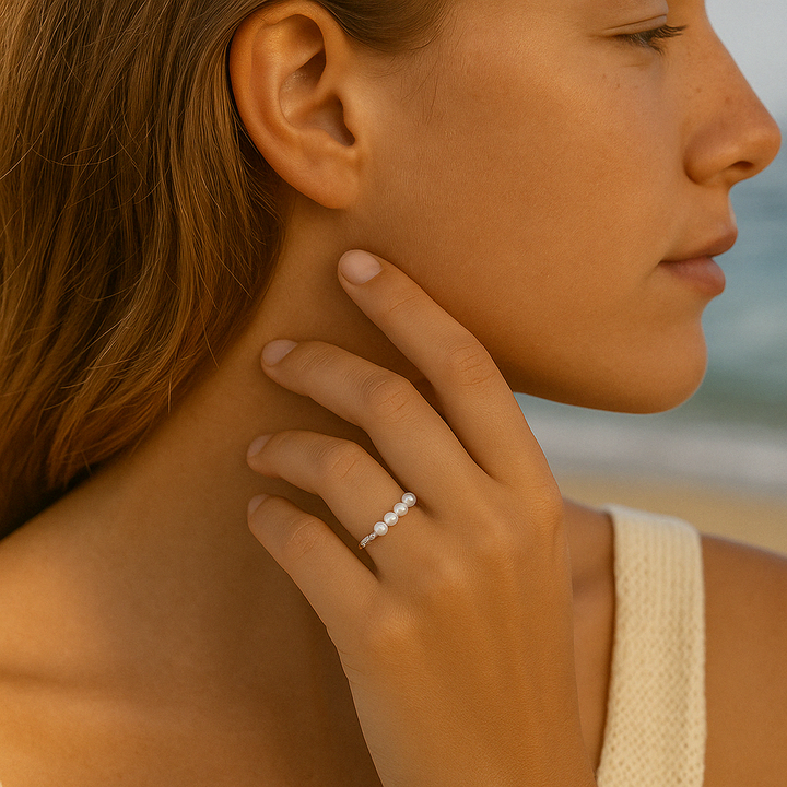 Bague Solyne en Argent 925 portée au doigt sur la plage, perle blanche élégante captant la lumière naturelle – Histoire d’Argent