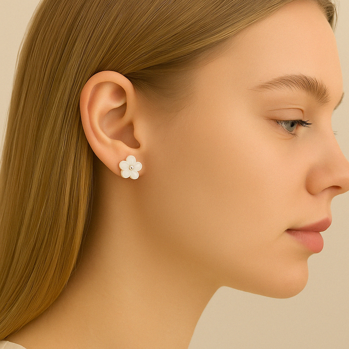 Zoom sur le cœur argenté des boucles en forme de fleur nacrée – finition brillante