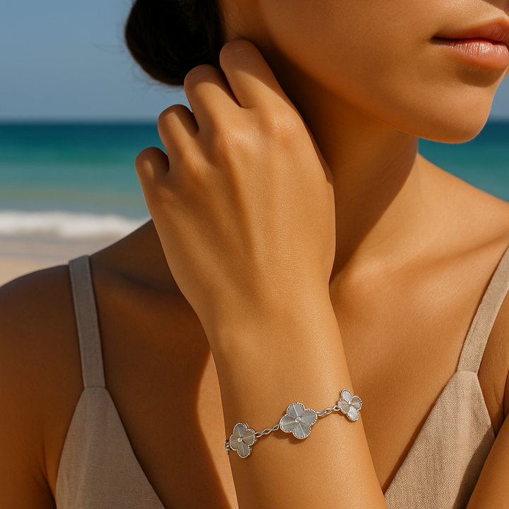 Bracelet gris Calandra en Argent blanc 925 porté sur la plage, mise en scène élégante au poignet d'une femme brune, ambiance estivale raffinée – Histoire d’Argent

