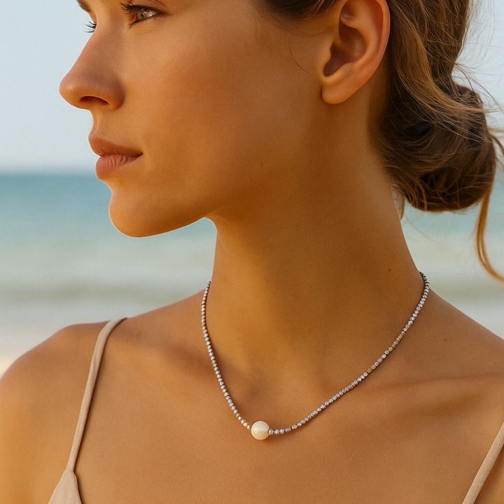 Collier femme perle naturelle porté en bord de mer – bijou lumineux, style d’été chic.