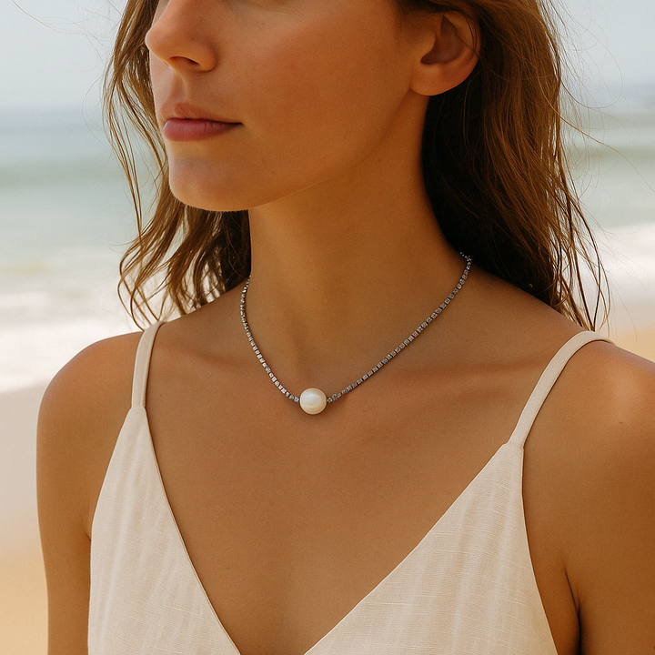 Collier en argent et perle porté au soleil – look estival raffiné, bijou intemporel.