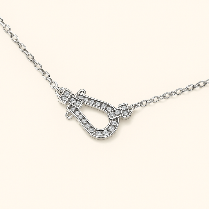 Vue de face du collier fer à cheval en Argent blanc 925 avec strass, suspendu délicatement, lumière naturelle douce sur fond crème élégant.