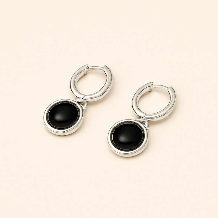 Boucles d’oreilles cabochon noir posées sur fond clair – finition Argent blanc 925 Sterling