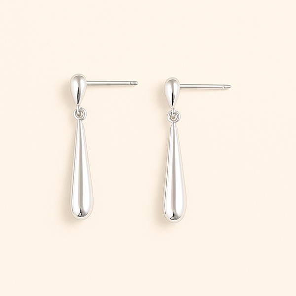 Vue de face des boucles d’oreilles en Argent Blanc 925, forme goutte minimaliste, fond doux.